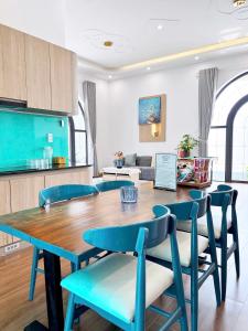 a dining room with a table and blue chairs at ECHO VILLA PHAN THiET in Phan Thiet