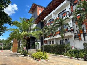 a building with palm trees in front of it at The Room Boutique Hotel in Sakon Nakhon