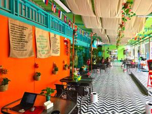 a restaurant with orange walls and tables and chairs at city mountain hotle in Vang Vieng