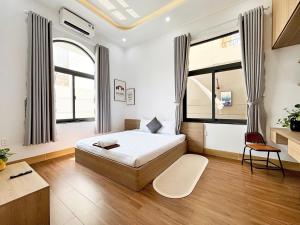 a bedroom with a bed and a chair in it at ECHO VILLA PHAN THiET in Phan Thiet