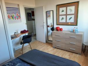 a bedroom with a dresser and a desk and a mirror at 360 degrés sur la rochelle chambre d hôte in La Rochelle +23 photos