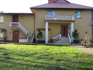 a house with stairs and a grass yard at Piligrimo Užeiga in Kadarės