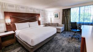 a hotel room with a large bed and a chair at DoubleTree by Hilton Madison Downtown in Madison