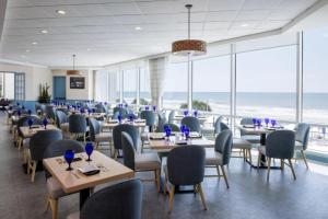 a dining room with tables and chairs and the ocean at Royale Palms Condominiums in Myrtle Beach