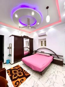 a bedroom with a pink bed and a purple ceiling at The white House in Aswan