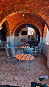 a table and chairs in a room with a brick wall at The white House in Aswan