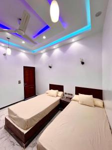 two beds in a room with blue lights on the ceilings at The white House in Aswan +9 photos