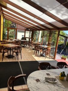 a restaurant with tables and chairs and windows at Hotel Gesellschaftshaus in Bergen auf Rügen