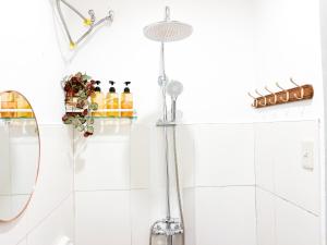 a white bathroom with a shower and a sink at Lelija Apartment in General Luna +17 photos