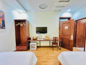 a room with two beds and a desk in it at An Velora Boutique Hotel in Lai Nghê (2)