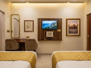 a hospital room with two beds and a mirror at Hotel Banaras Vandanam in Varanasi