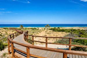 a wooden path to the beach with the ocean in the background at Beachfront Luxury Apartments by NRAS in Arenales del Sol