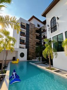 a pool in front of a house with a blue water slide at The Room Boutique Hotel in Sakon Nakhon