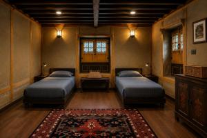 a bedroom with two beds and a rug at Shepherd Barn Pahalgam in Pahalgām +6 photos