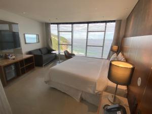 a hotel room with a bed and a view of the ocean at Hotel Nacional Rio in Rio de Janeiro