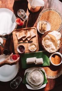 a wooden table with plates of food on it at The Mudhouse Marayoor in Munnar +65 photos