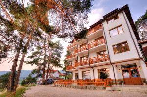 a large white building with wooden balconies on it at Villa Santa Maria in Tsigov Chark