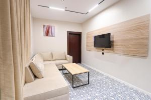 a living room with a couch and a tv on a wall at فندق سويتس لاين in Medina +13 photos