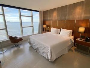 a bedroom with a large bed and large windows at Hotel Nacional Rio in Rio de Janeiro