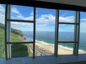 a view of a beach from a window at Hotel Nacional Rio in Rio de Janeiro