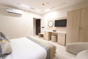 a bedroom with a bed and a desk and a television at فندق سويتس لاين in Medina