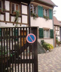 a sign on a fence in front of a house at charmant petit appartement en Alsace in Bouxwiller