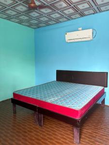 a bed in a room with a blue wall at Bhudda Lodge in Tirupati