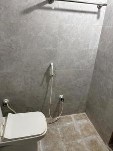 a bathroom with a toilet and a shower stall at Bhudda Lodge in Tirupati