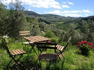 uma mesa de piquenique e duas cadeiras sentadas no topo de uma colina em Agriturismo Villa Dauphiné em Bagno a Ripoli