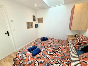 a bedroom with a bed with a colorful blanket on it at Chez Simone in Ploemeur