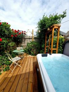 a backyard with a hot tub and a table and chairs at Chez Simone in Ploemeur