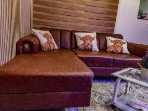 a brown couch with pillows on it in a living room at Wiwi Appartement in Kinshasa +1 photo