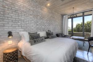 a bedroom with a brick wall and a bed with pillows at The House Quarters in Kenton on Sea +40 photos
