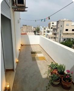 a balcony with potted plants on top of a building at Résidence Nour in Monastir