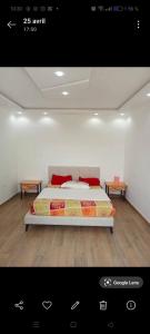 a bedroom with a bed and two end tables at Résidence Nour in Monastir