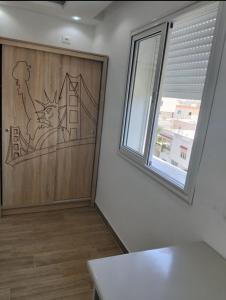a room with a wooden door with a cat on it at Résidence Nour in Monastir