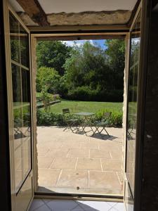 an open door to a patio with a view of a yard at domaine grangieras in Château-lʼÉvêque