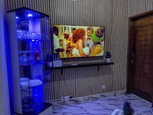 a tv on a wall with a picture on it at Wiwi Appartement in Kinshasa