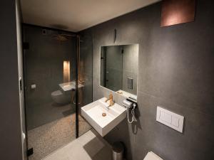 a bathroom with a sink and a mirror at NOX HOTEL - Digital-Check-In - No Reception - nahe Bretten & Karlsruhe - 1 Grey in Wössingen
