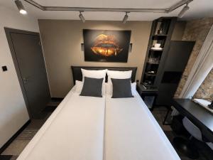 a large white bed with pillows in a room at NOX HOTEL - Digital-Check-In - No Reception - nahe Bretten & Karlsruhe - 1 Grey in Wössingen