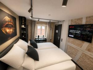 a bedroom with two beds and a couch in it at NOX HOTEL - Digital-Check-In - No Reception - nahe Bretten & Karlsruhe - 1 Grey in Wössingen