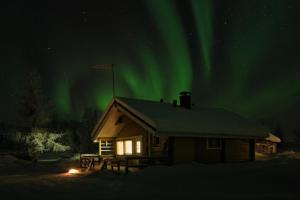 a cabin with the aurora in the sky at Polar Tranquil Cabins in Kittilä
