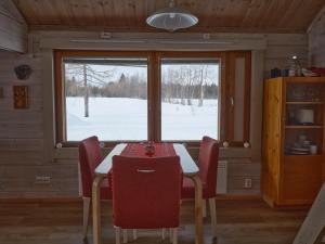 a dining room with a table and chairs and a window at Polar Tranquil Cabins in Kittilä