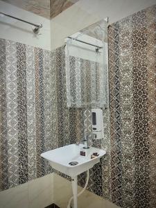 a bathroom with a sink and a mirror at Sky Hotel in Lucknow