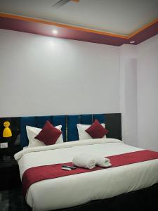 a bedroom with a large white bed with red pillows at Sky Hotel in Lucknow