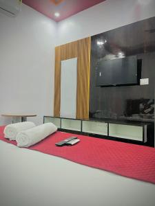 a bedroom with a bed with a flat screen tv at Sky Hotel in Lucknow