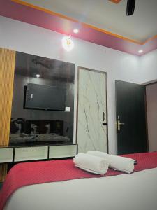 a bedroom with a bed with two white towels on it at Sky Hotel in Lucknow