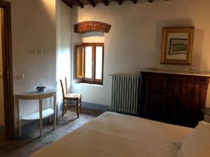 a bedroom with a bed and a table and a window at Agriturismo Villa Dauphiné in Bagno a Ripoli