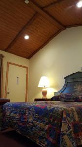 a bedroom with a bed with a lamp on a table at Atlantic Motel in Point Pleasant Beach