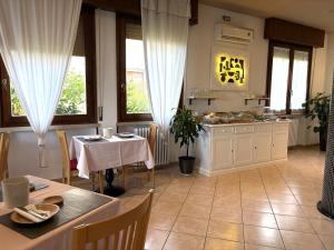 a kitchen and dining room with a table and chairs at Hotel Renata in Lazise
